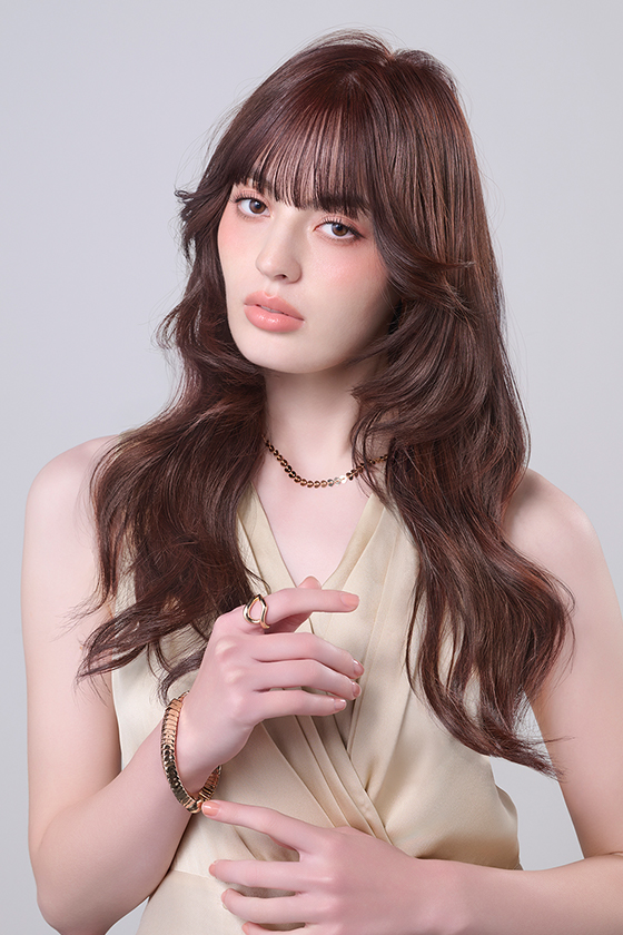 やわらかいオレンジ系でカラーしたロングヘアの女性