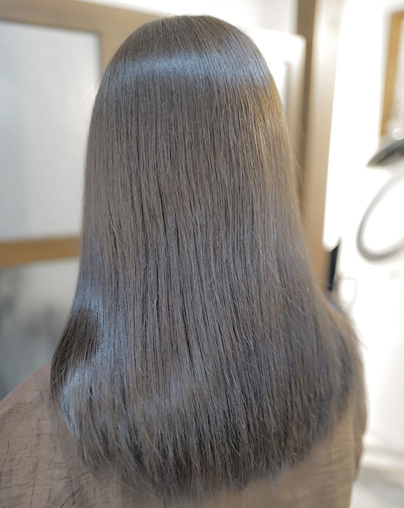 アッシュベージュ系でカラーしたロングヘアの女性