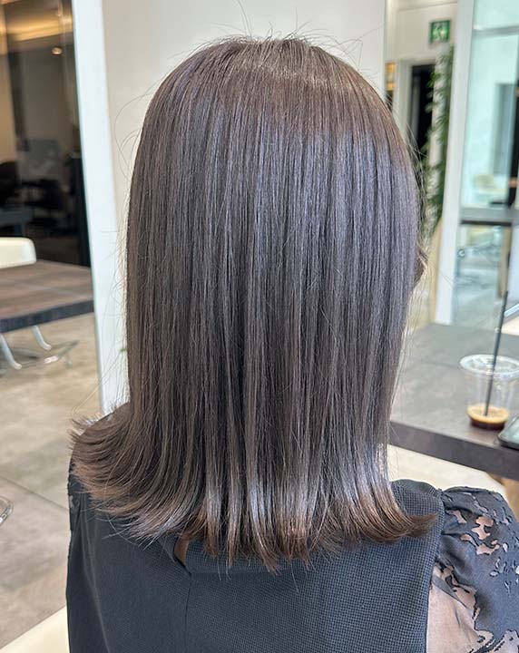 グレージュ系でカラーしたミディアムレングスの女性